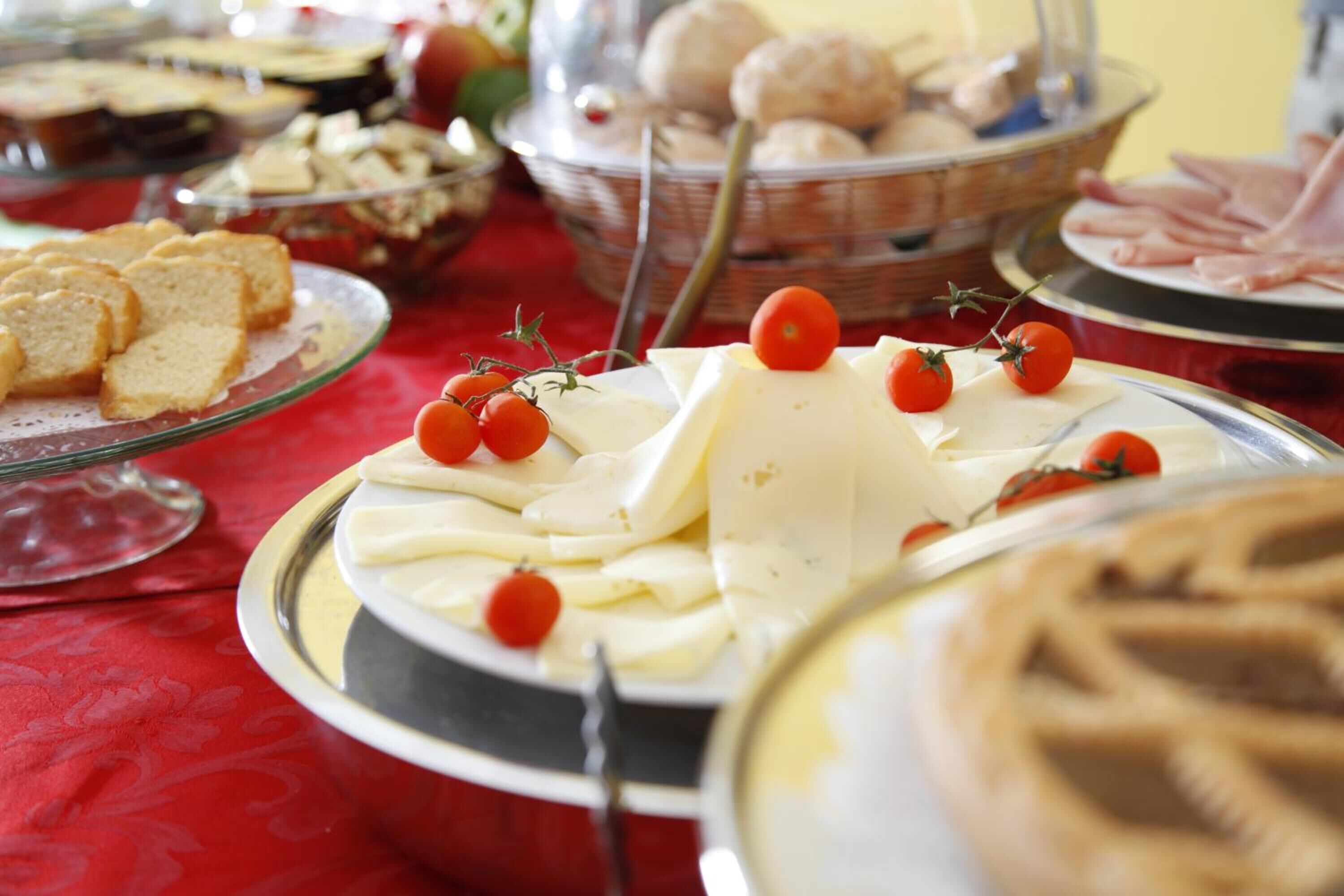 Ein Buffet mit verschiedenen Speisen, darunter Käse, Brot und Gebäck.