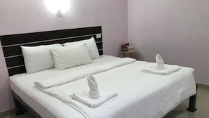 A double bed with white linens and towels, a bedside table with a lamp, and a wall-mounted light fixture. - Hotel Murano Phang-Nga Bay (Phang Nga)