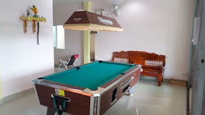 A pool table in a room with a ceiling fan, a wooden bench, and a wall-mounted decoration. - Hotel Murano Phang-Nga Bay (Phang Nga)