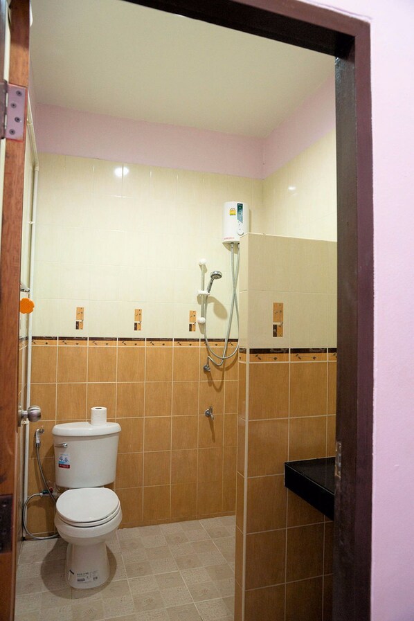 Un baño con inodoro, ducha y lavamanos.