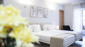 Habitación de hotel con dos camas, una puerta de madera, una silla y cuadros en la pared.