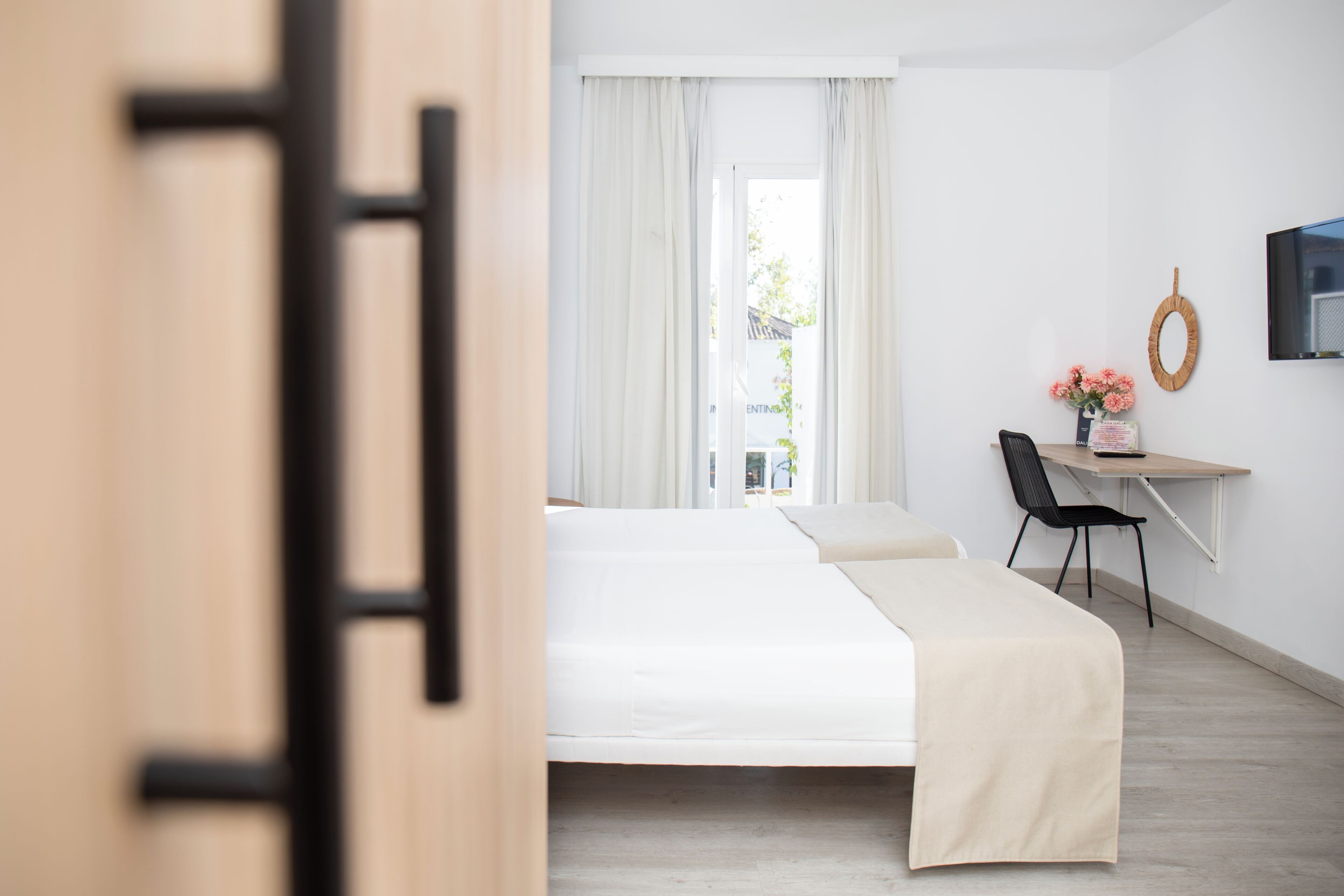 Ett modernt hotellrum med en säng, ett skrivbord och en stol.