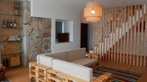 Ein modernes Wohnzimmer mit einer Steinwand, einem Holzdile und einem Pendelleuchten sowie einem Streifenmusterteppich.