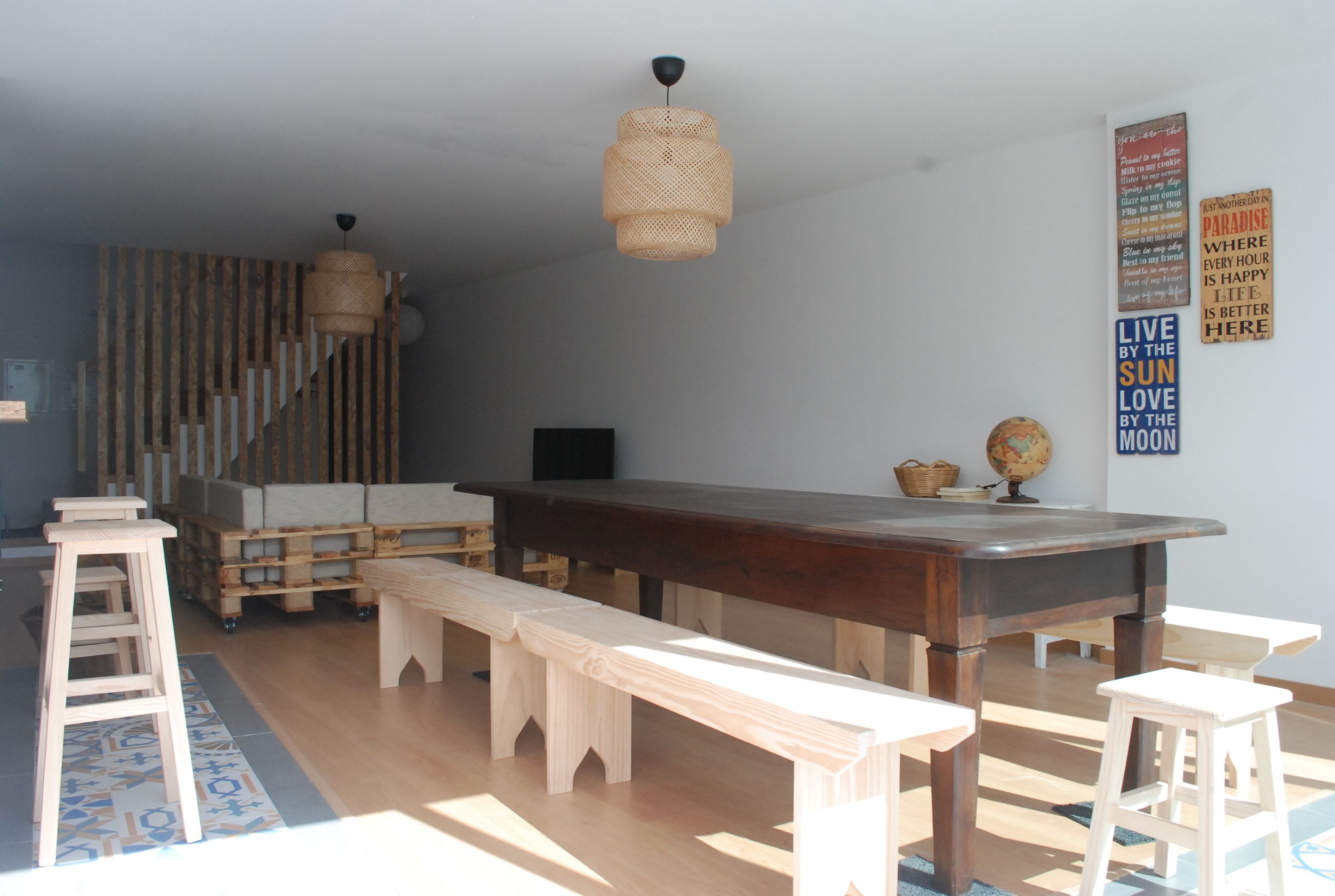 Ein modernes Wohnzimmer mit Couchtisch, Bänken und einer Pendelleuchte.