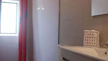 Ein Badezimmer mit Toilette, Waschbecken und Duschvorhang. An der Wand ist ein Schild mit der Aufschrift 'ESPO-SENDE GUEST HOUSE'.