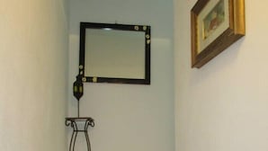 Una escalera con una pequeña mesa y un espejo en la pared.
