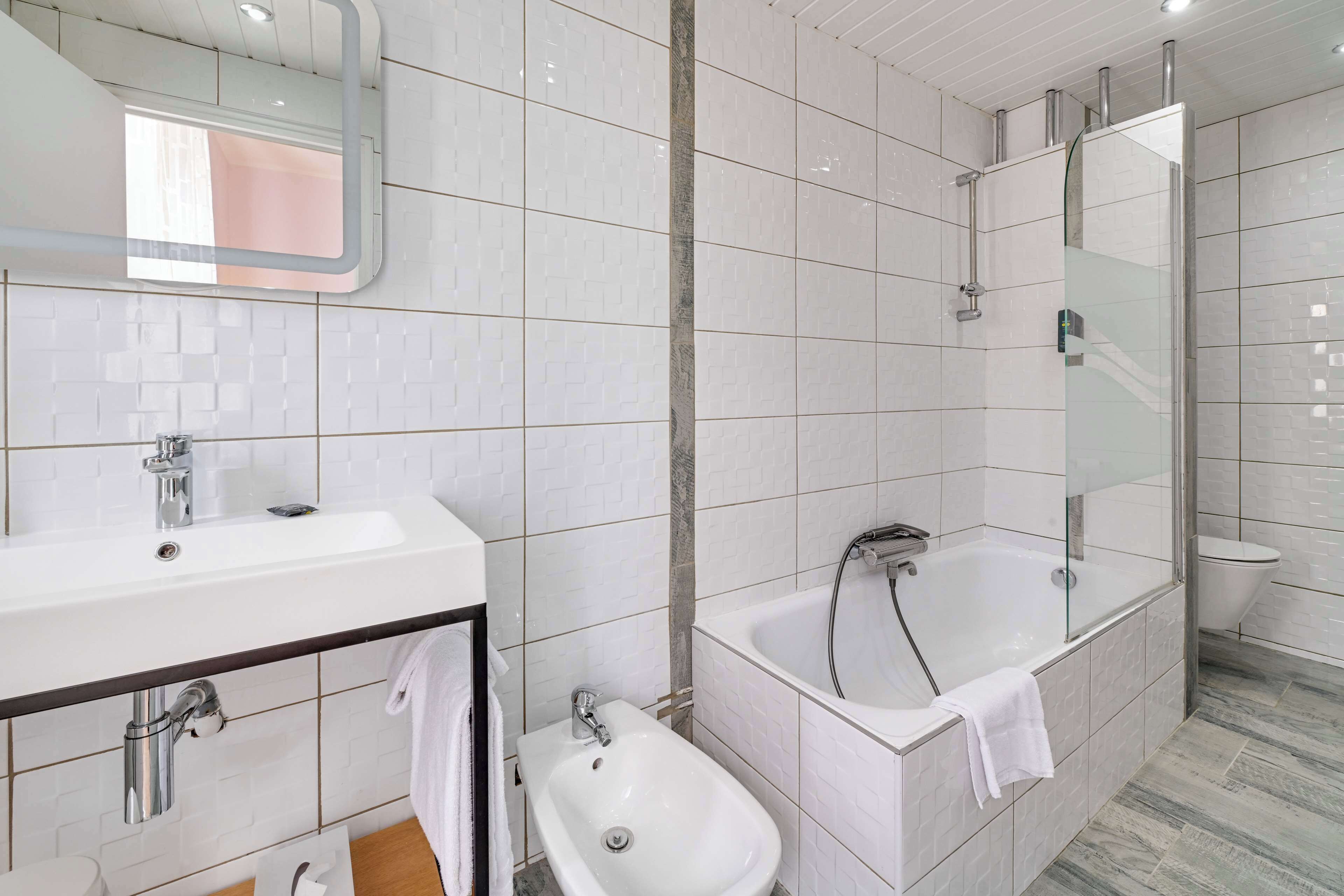 Une salle de bain moderne équipée d’un lavabo, d’un bidet et d’une baignoire.