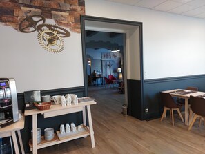 Un café moderno con suelo de madera, una máquina de café y un adorno de engranajes en la pared.
