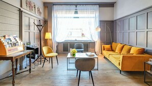 Una sala de estar moderna con un sofá, sillas, una mesa de centro y un escritorio con un cartel.