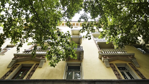 Un edificio con fachada simétrica, múltiples ventanas y balcones.