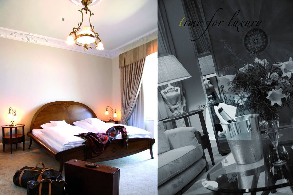 A well-appointed bedroom with a large bed, bedside lamps, and a suitcase on the floor.
