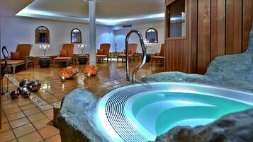 Een wellnessruimte met een jacuzzi, zitplaatsen en decoratieve details.