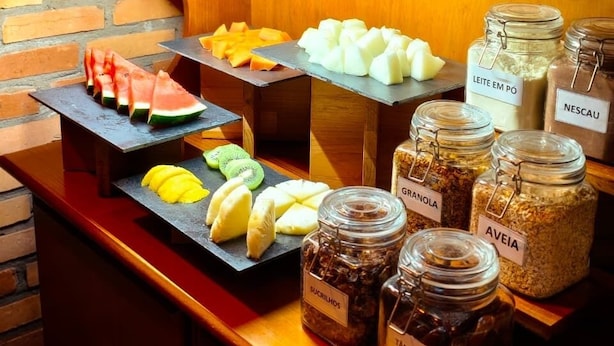 Ein Frühstücksbuffet mit verschiedenen Früchten, Käsesorten und Beilagen.