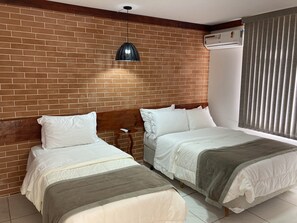 Standaard driepersoonskamer | Een minibar, een laptopwerkplek, verduisterende gordijnen