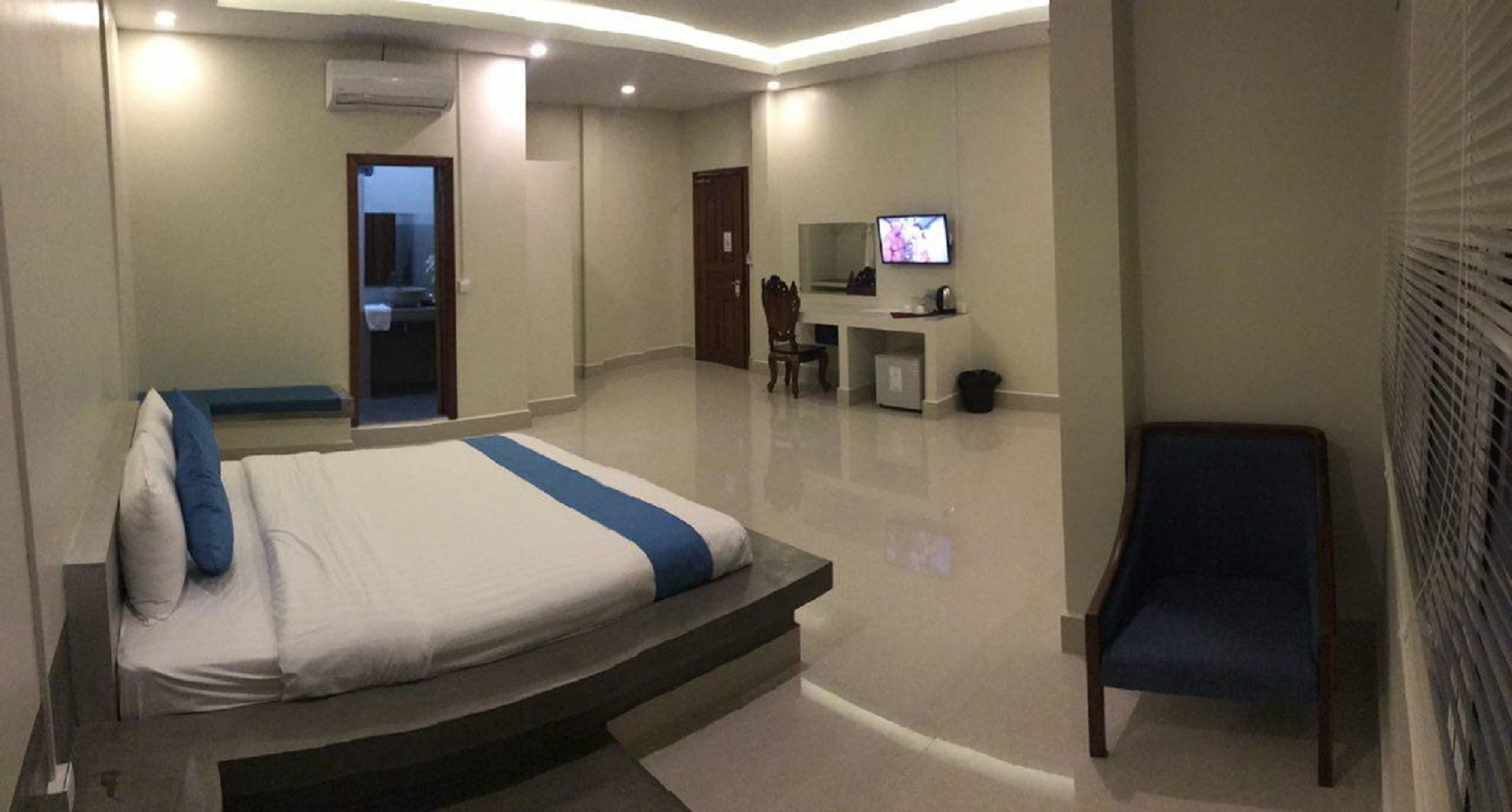 Een hotelkamer met een bed, een bureau, een stoel en een televisie.