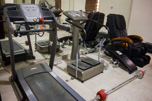 A gym with exercise equipment including treadmills, a weight bench, and a rowing machine. - De' Bliss Hotel and Suites (Lagos)