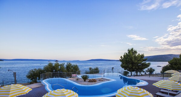 A swimming pool with a view of the sea, surrounded by trees and umbrellas. - Mediteran Travel Mobile Homes Belvedere (Seget)