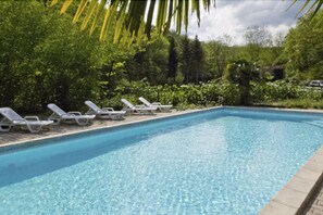 Een buitenzwembad en ligstoelen