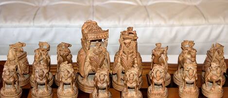 A chess set with intricately carved figures on a checkered board.