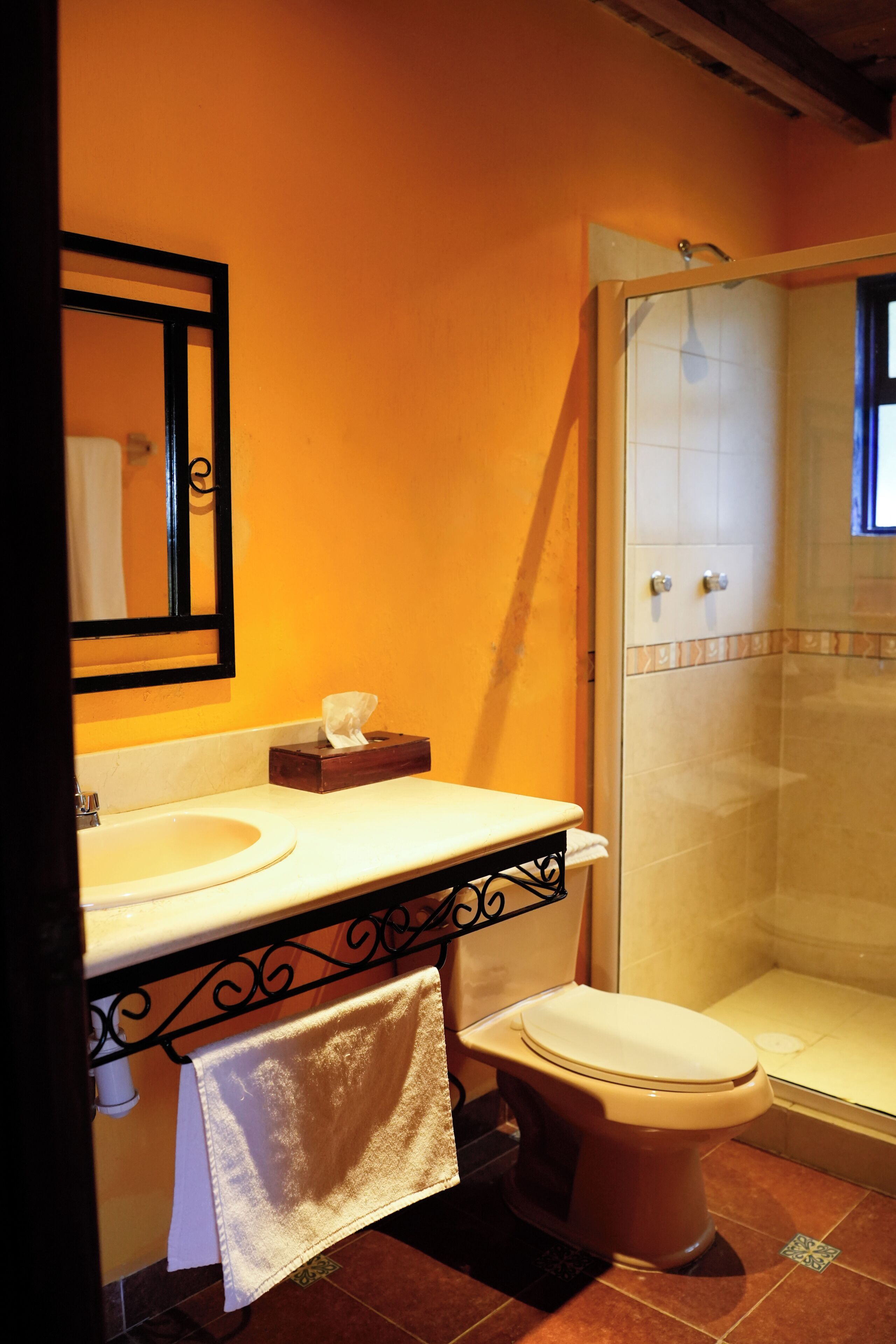A bathroom with a sink, toilet, and glass-enclosed shower.