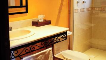 A bathroom with a sink, toilet, and glass-enclosed shower.