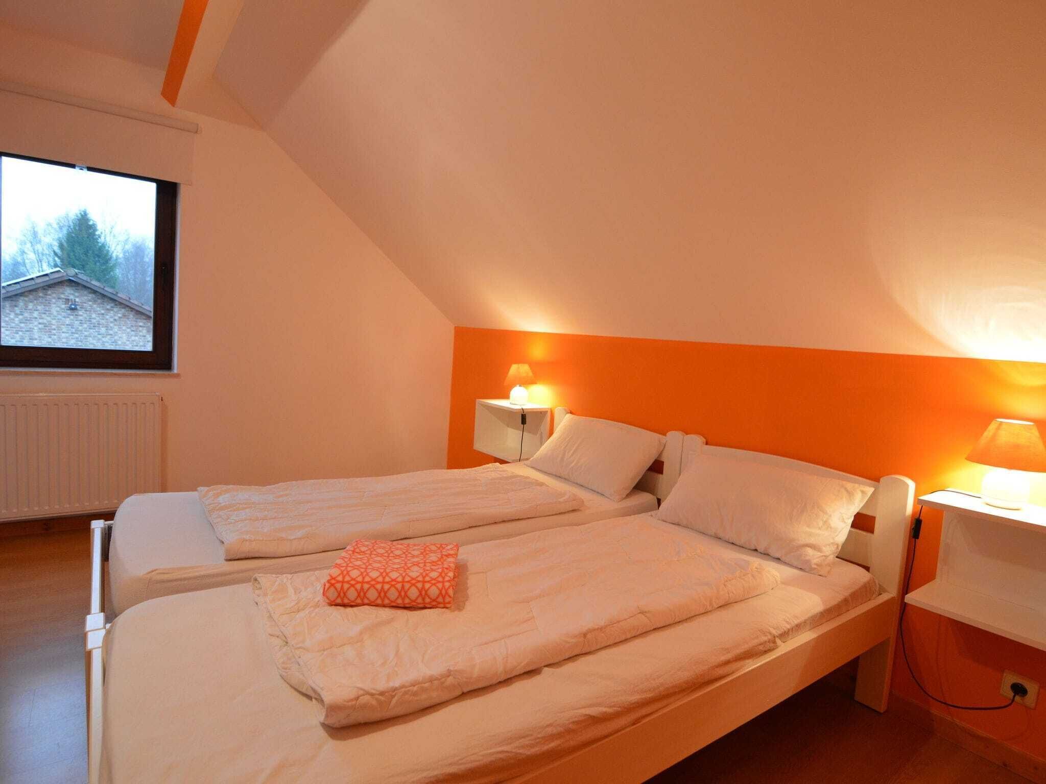 A bedroom with two beds, a window, and a radiator.