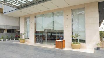 A modern building with a reception desk, large glass windows, and potted plants.