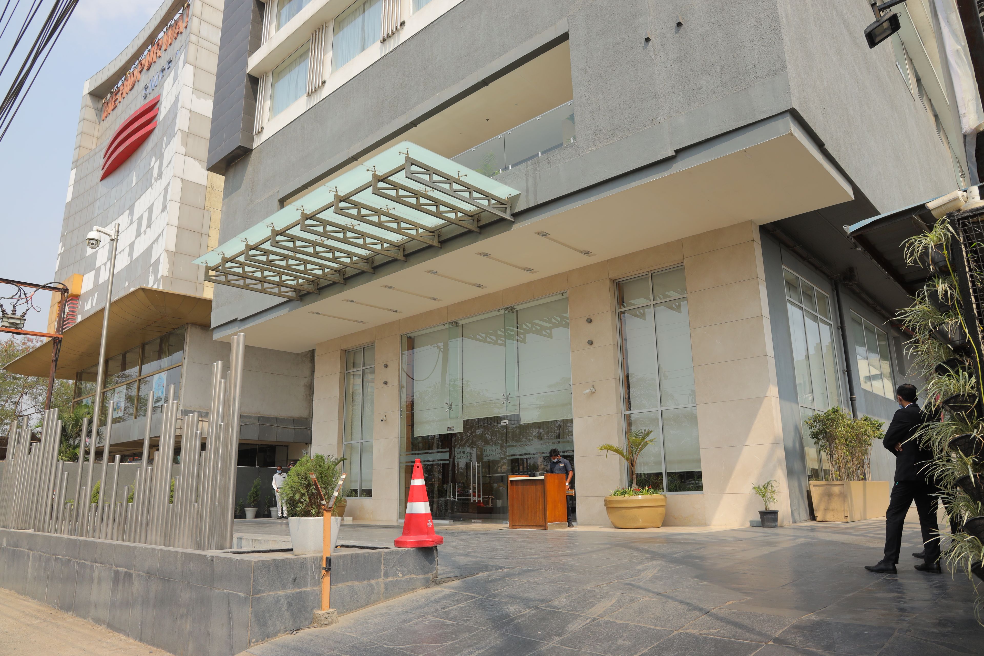 A modern building with a glass facade, a reception desk, and a security camera.