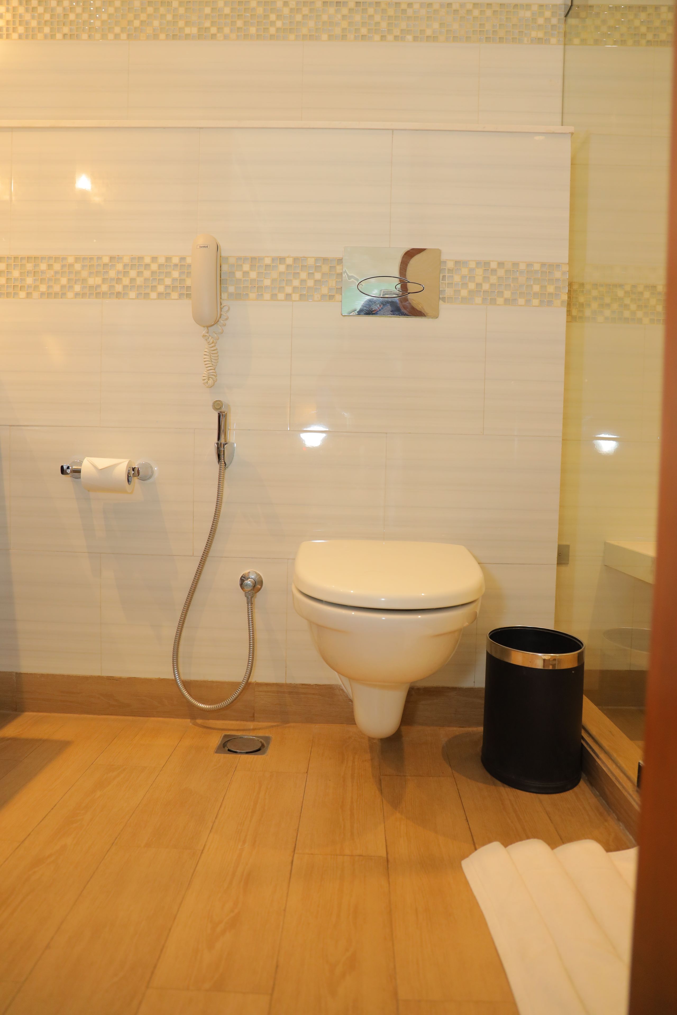 A bathroom with a toilet, a shower, and a hand dryer.