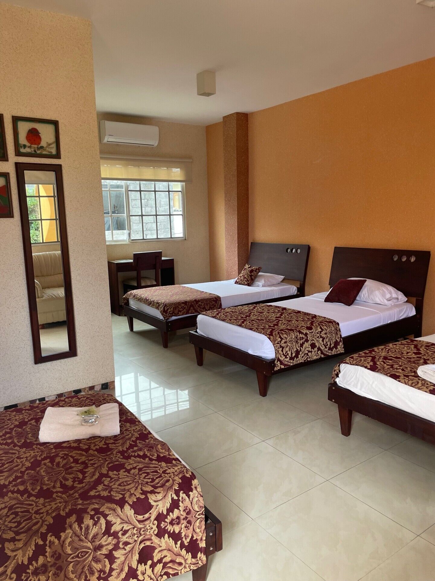 A hotel room with two beds, a desk, and a chair.