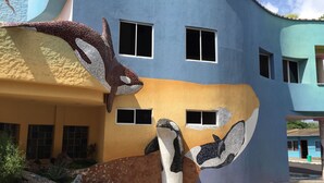 Ein Gebäude mit einer außergewöhnlichen Fassade, die mit Mosaiken von Meereslebewesen gestaltet ist.
