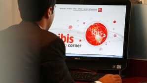Una persona utilizando un computador Dell con una pantalla que muestra un sitio web con íconos y texto relacionados con internet, correo electrónico, chat, trabajo de oficina y redes sociales.