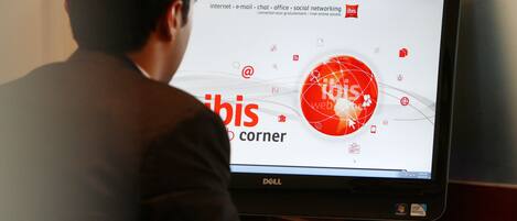 A person using a Dell computer with a screen displaying a website with icons and text related to internet, email, chat, office, and social networking.