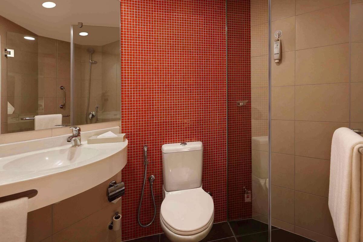 A bathroom with a white sink, toilet, and shower.