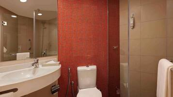 A bathroom with a white sink, toilet, and shower.