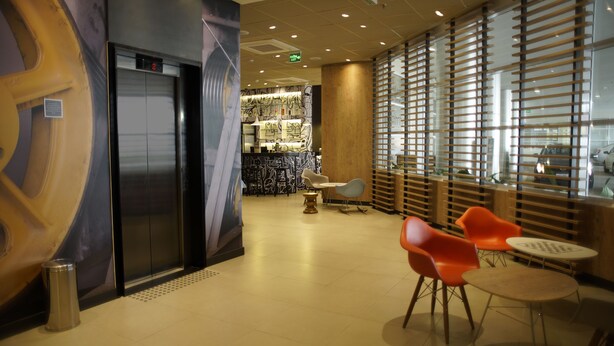 A modern lobby with a reception desk, seating area, and an elevator. - Ibis Osasco (Osasco)