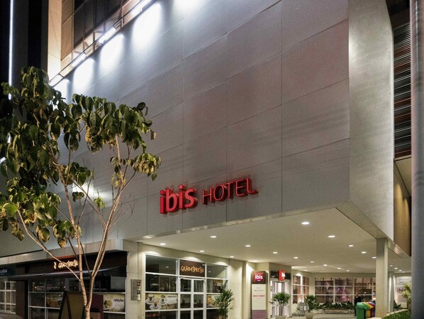 Exterior del hotel ibis, con fachada moderna, ventanas amplias y señalización llamativa.