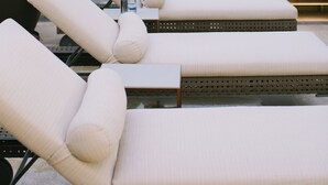 Un espace de détente aménagé sur le toit, avec des fauteuils confortables, un grand bac à plantes et des chaises suspendues.