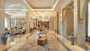 A spacious lobby with a modern design, featuring a central seating area, decorative vases, and a geometric patterned wall. - Hyatt Regency Tashkent (Tashkent)