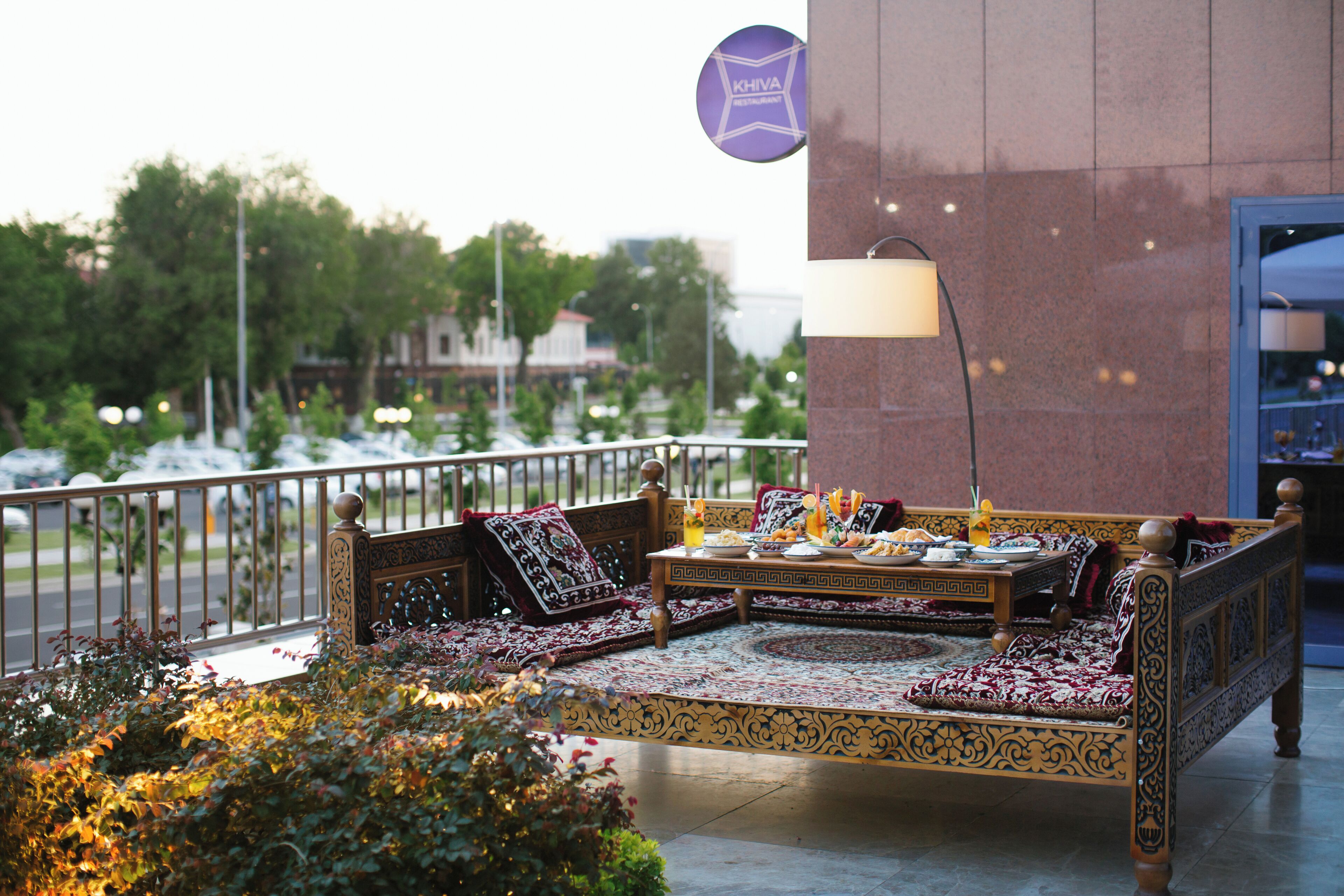 A traditional sofa set with cushions and a table, a lamp, and a sign indicating a restaurant.