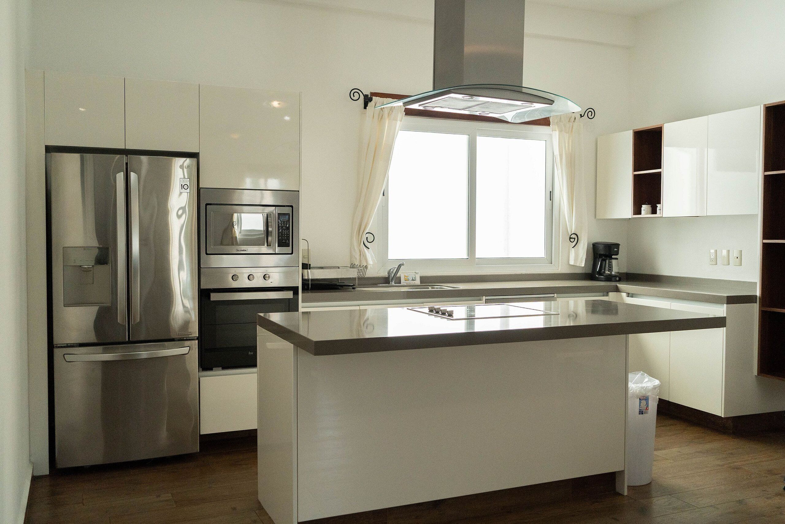 A modern kitchen with a stainless steel refrigerator, oven, and microwave.