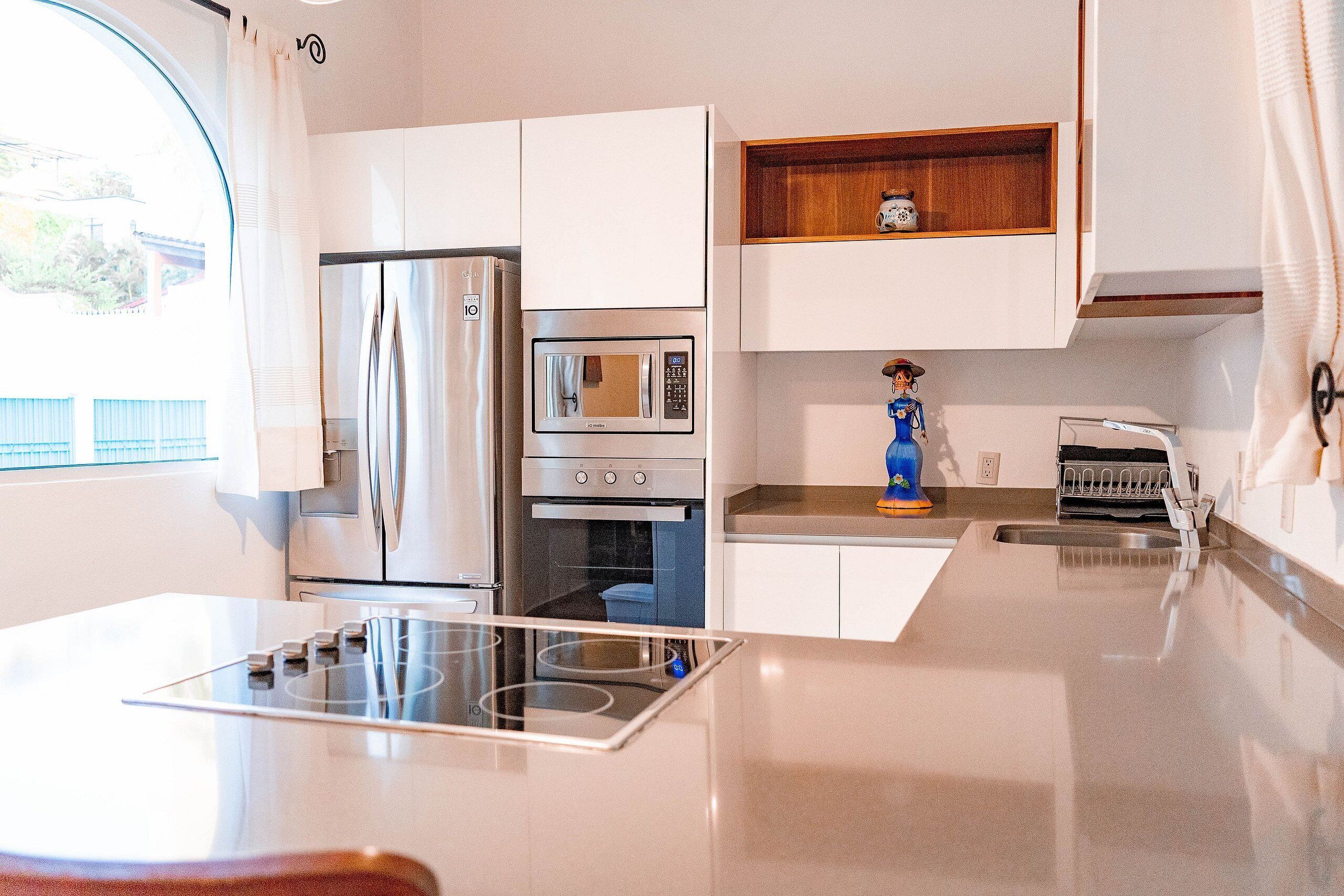 A modern kitchen with stainless steel appliances, a built-in oven, and a microwave.
