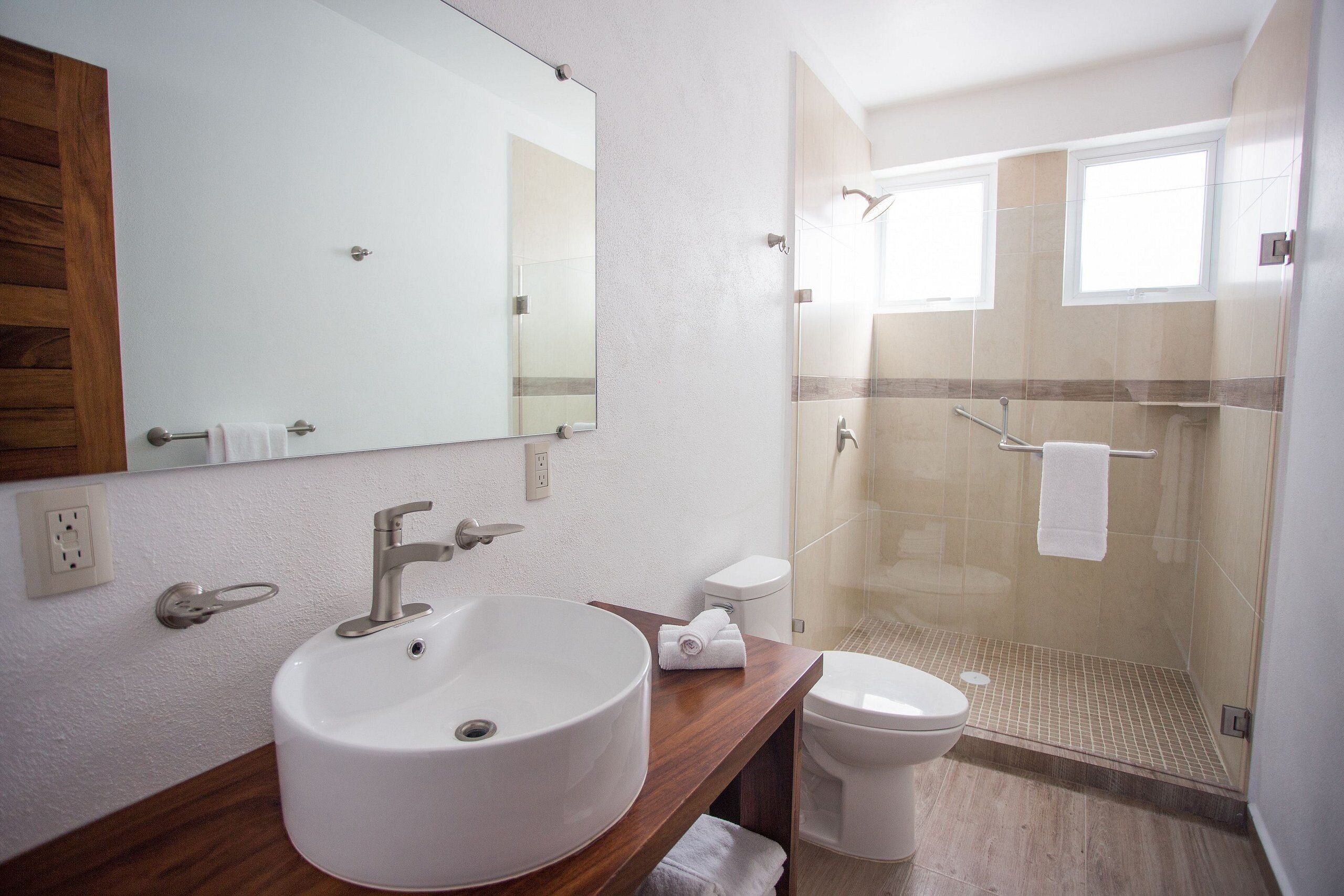 Ein Badezimmer mit großem Waschbecken, Toilette und einer Duschkabine.
