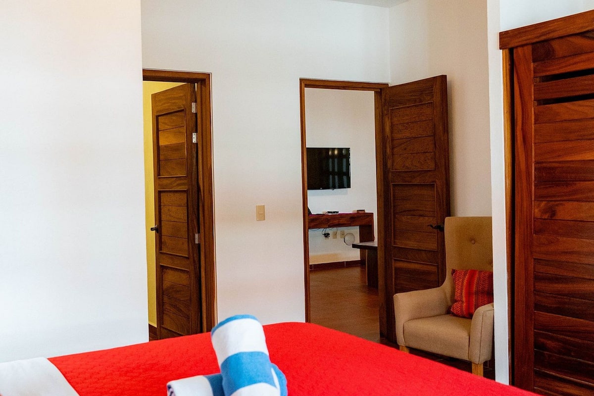 Ein Hotelzimmer mit einem großen Bett, einem Holzschrank und einem Deckenventilator.