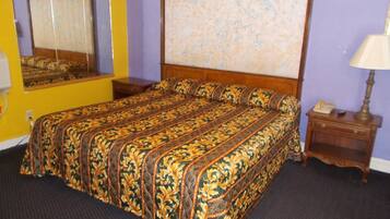Une chambre à coucher avec un grand lit, une tête de lit en bois, une table de chevet, une lampe et un miroir.