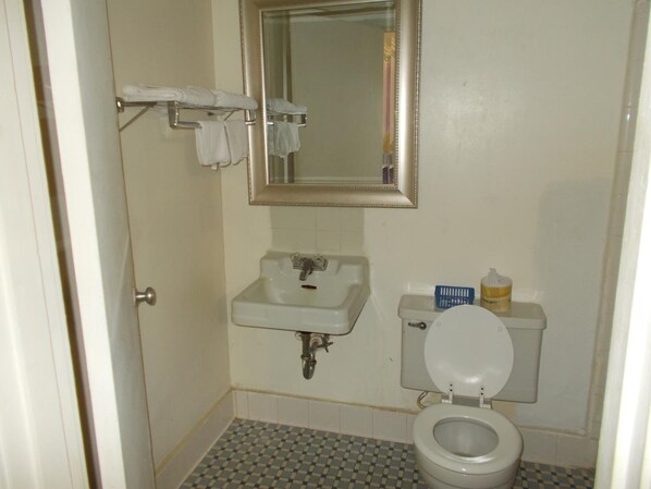 Un baño pequeño con un lavabo blanco, un espejo y un inodoro.