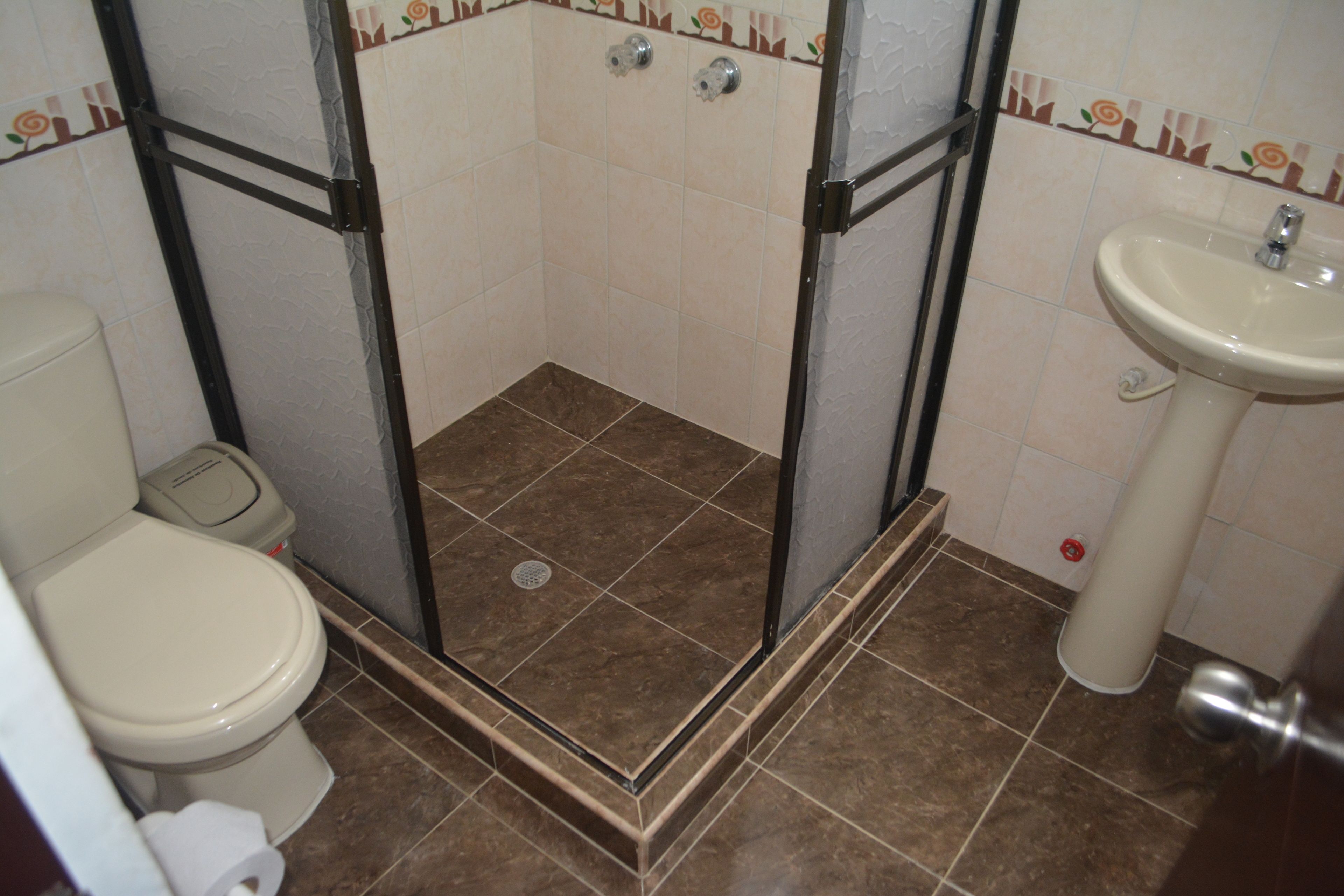 Ein Badezimmer mit Dusche, Toilette und Waschbecken.