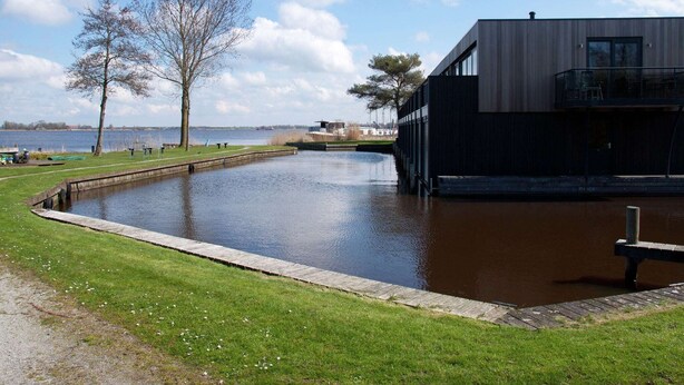 A modern building with a large water feature in front.