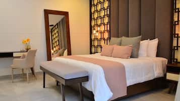 Un dormitorio con una cama grande, una mesita de noche, una silla, un escritorio y un panel decorativo en la pared.