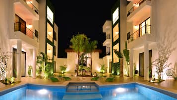 Una piscina al aire libre, sillones reclinables de piscina